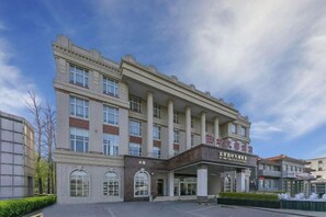A multi-story hotel with a central entrance, large windows, and a clear sky. - Yangfang Dadu Hotel (Beijing)