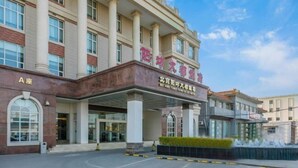 A hotel entrance with a covered area, columns, and a clear sky. - Yangfang Dadu Hotel (Beijing)