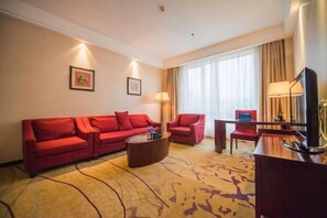 A hotel room with a red sofa set, a coffee table, a TV, and a large window with curtains. - Yangfang Dadu Hotel (Beijing)