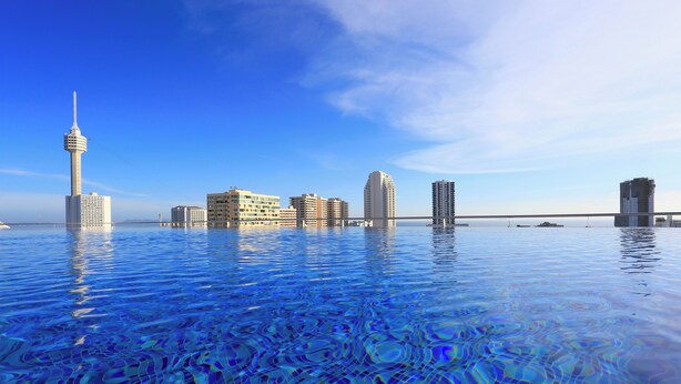 A waterfront hotel with a clear view of the city skyline, including a prominent tower and several high-rise buildings. - Sirin Exclusive Hotel & Residence (Pattaya)