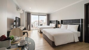 A hotel room with two beds, a dining area, and a balcony with a city view. - Sirin Exclusive Hotel & Residence (Pattaya)