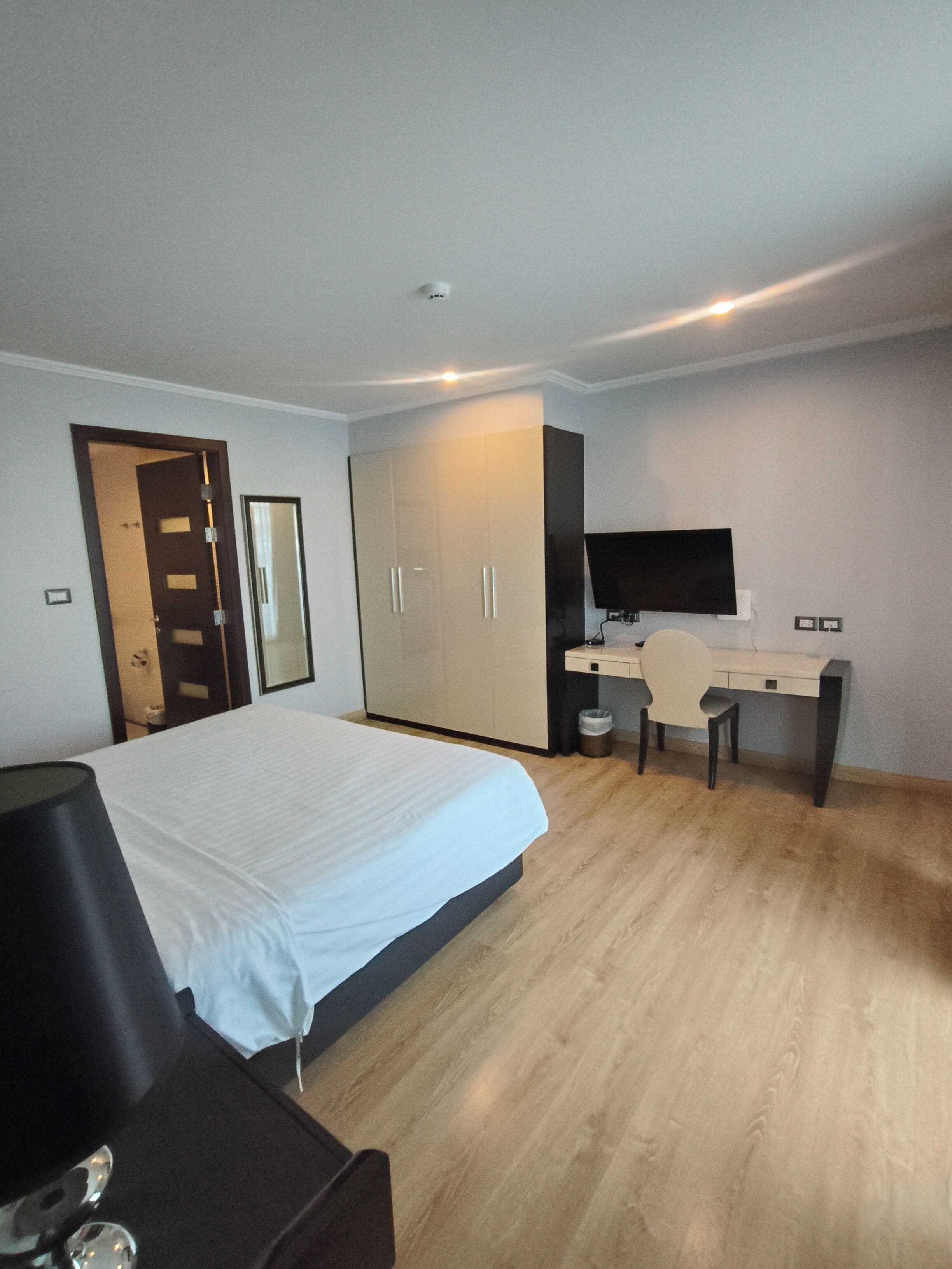 Une chambre d’hôtel équipée d’un lit, d’un bureau, d’une chaise, d’une télévision et d’une armoire.