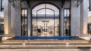 A grand entrance with a marble facade, large glass doors, and a modern interior visible through the entrance. - Sirin Exclusive Hotel & Residence (Pattaya)
