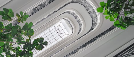 A multi-level interior with ornate black and white patterns on the walls and a central skylight.
