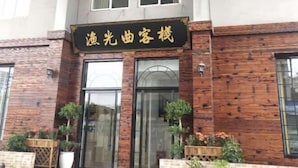 A building facade with a black signboard and wooden paneling. - Taicang Your Crown Trip Inn (Taicang)