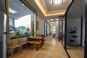 A spacious corridor with a wooden dining table and chairs, a kitchen area with appliances, and a view through a large window. - Taicang Your Crown Trip Inn (Taicang)