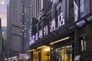 Un hotel con fachada moderna, señalización iluminada y entrada visible.