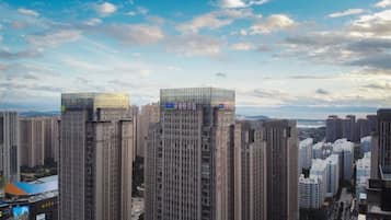 A cityscape with high-rise buildings, including a prominent building with a glass top.