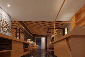 Ein modernes Interieur mit Holzbalken, einer Treppe und Blick in einen weiteren Raum.