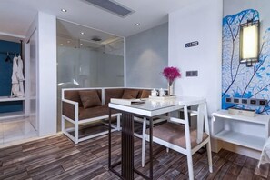 A modern room with a glass partition, a white table with a vase, and a blue abstract painting on the wall. - Feilite Hotel (Kunming)