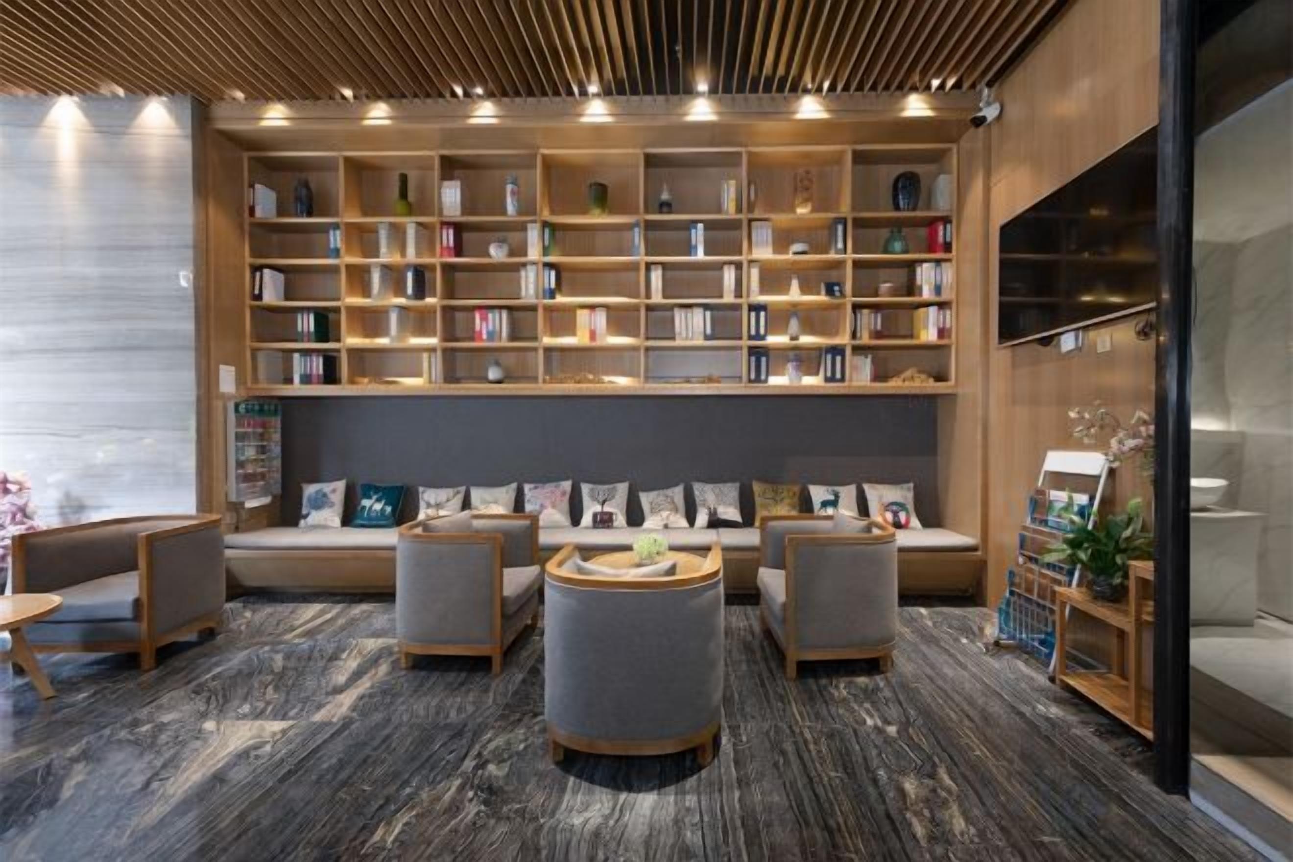 A modern library with bookshelves, seating areas, and a coffee table.