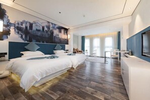Quarto de hotel moderno com uma cama grande, uma escrivaninha e uma televisão.