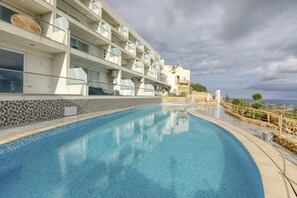 Relax by the pool surrounded by a stone wall and enjoy breathtaking views of the sea.