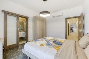 Relax in a stylish room with a large bed, bedside table, and mirror.
