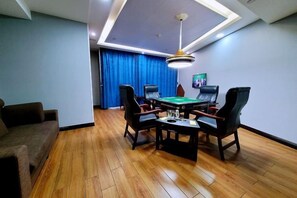 A room with a pool table, four chairs, a sofa, and a ceiling light fixture. - Bosite Boutique Theme Hotel (Taizhou)