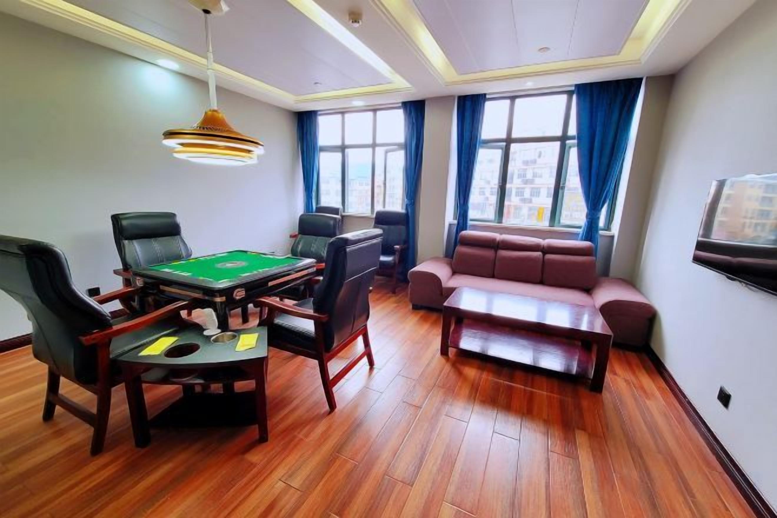 A room with a pool table, leather chairs, a sofa, and a television.