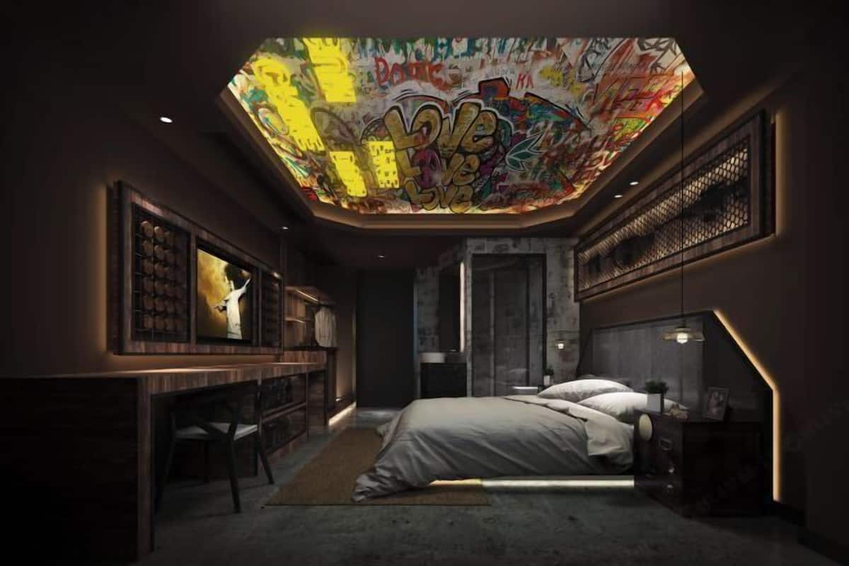 A modern bedroom with a graffiti-themed skylight, a desk, and a bed with a nightstand.