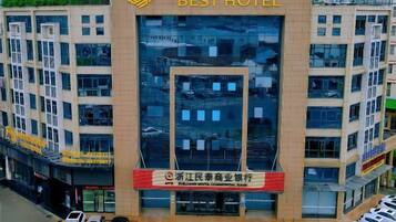 Un edificio de hotel de varios pisos con un llamativo letrero que dice 'BEST HOTEL'.