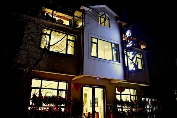 A multi-story building with illuminated signage and windows.