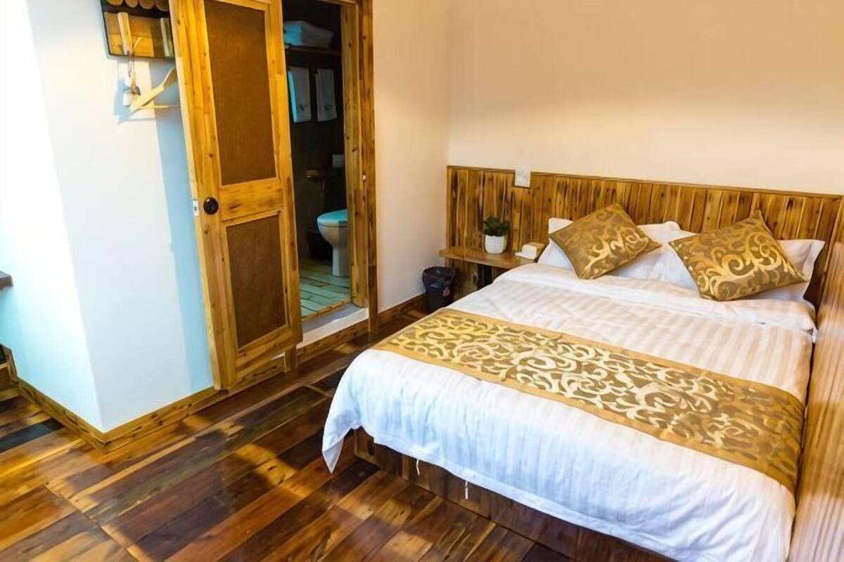 A bedroom with a wooden bed, a wooden headboard, a bedside table, and a wardrobe.