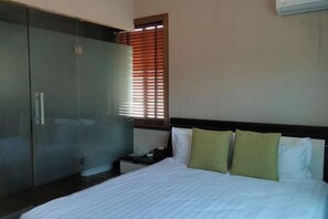 A bedroom with a bed, a wardrobe, a nightstand, and a window with blinds. - Qingmei Zhuma Inn (Deqing)