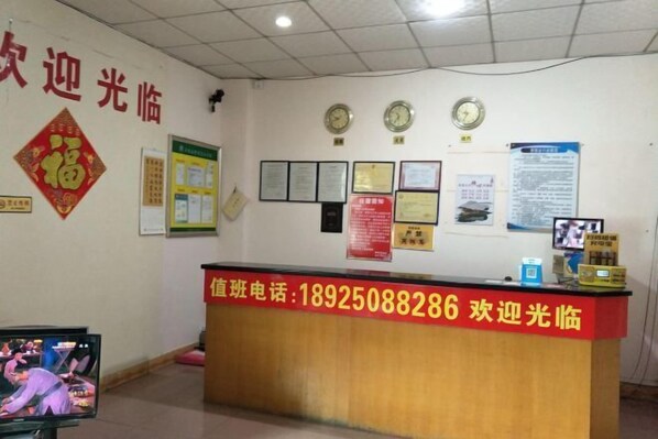 A reception desk with a phone number and a clock above it. - Pearl Hotel (Nanxing Second Road) (Zhaoqing)