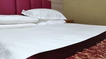 A bed with white bedding and a red headboard.