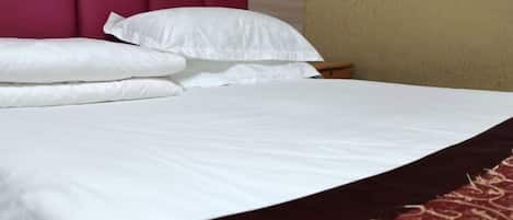 A bed with white bedding and a red headboard.