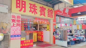 A storefront with a prominent sign, a display window, and various items for sale.