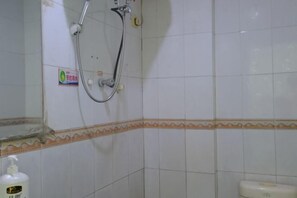 A bathroom with white tiles, a shower, a toilet, and a soap dispenser. - Pearl Hotel (Nanxing Second Road) (Zhaoqing)