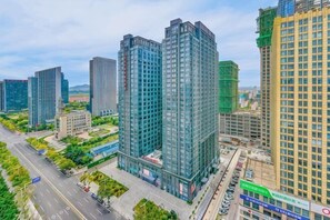 A high-rise building complex with multiple skyscrapers, a central road, and surrounding greenery. - Midland Marriott Hotel (West Coast New Area City Balcony Branch) (Qingdao)