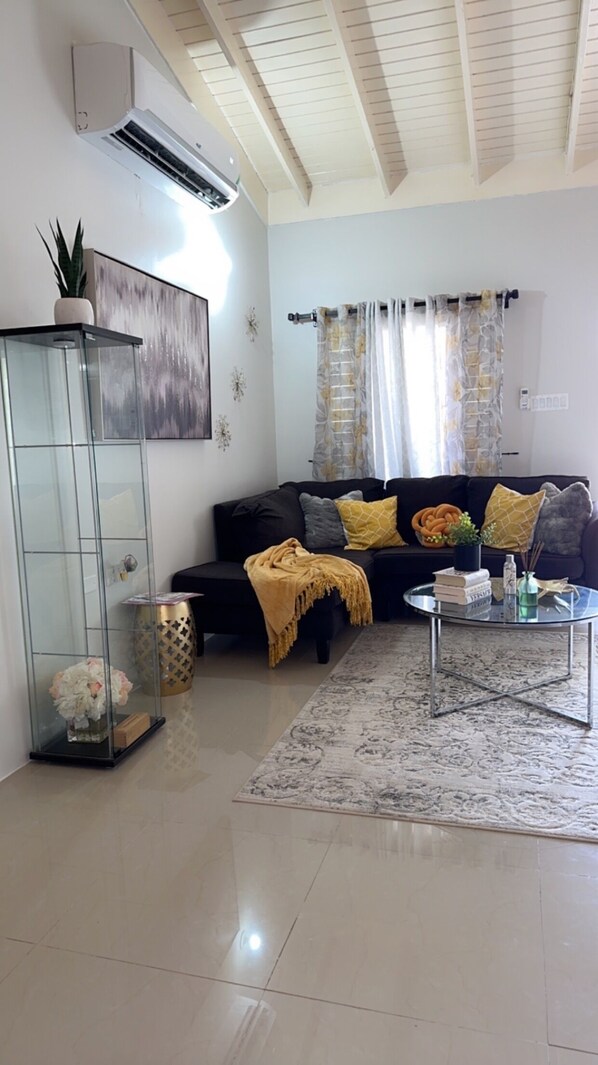 A living room with a black sofa, a glass cabinet, and a coffee table.