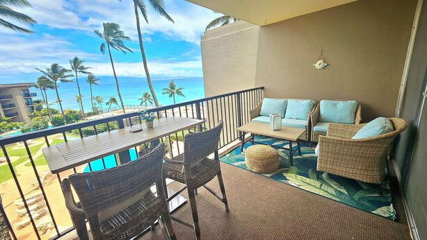 A balcony with a view of the ocean, a pool, and outdoor furniture. -  NO PARKING & RESORT FEE IN WEST MAUI WITH AMAZING OCEAN VIEW CONDO (Lahaina)