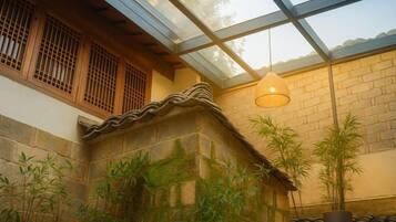 A traditional building with a stone wall, wooden window frames, and a glass ceiling.