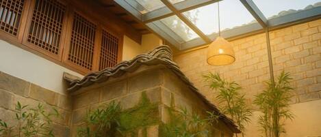 A traditional building with a stone wall, wooden window frames, and a glass ceiling.