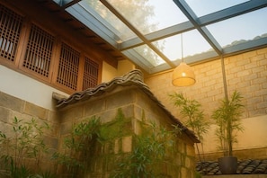 Un bâtiment traditionnel avec un mur en pierre, des encadrements de fenêtres en bois et un plafond en verre.