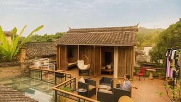 A traditional-style building with a wooden exterior and a glass-enclosed patio area with outdoor seating.