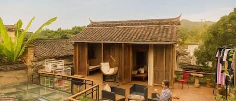 A traditional-style building with a wooden exterior and a glass-enclosed patio area with outdoor seating.