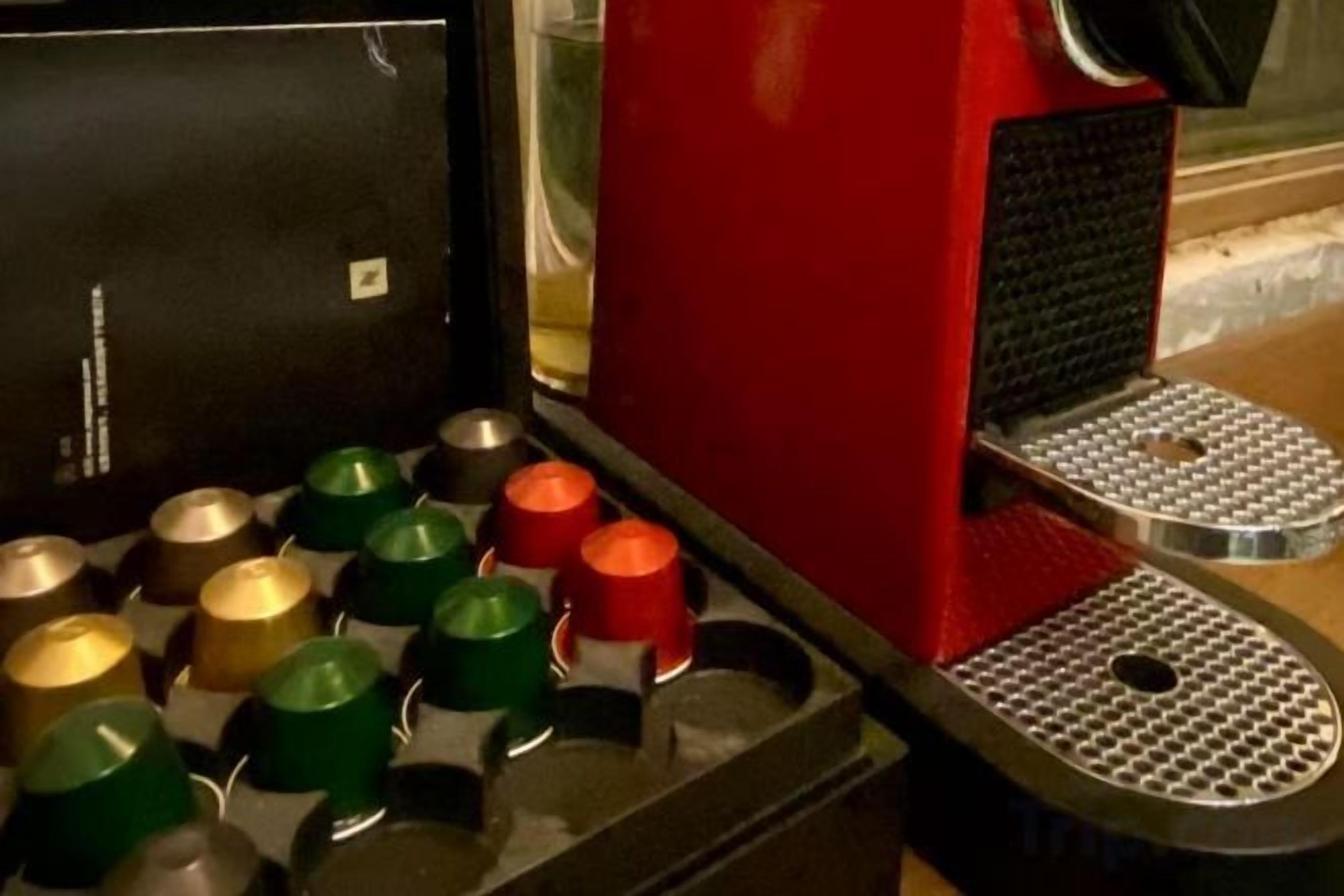 Eine Kaffeemaschine mit einem Metalltablett und roter Basis.