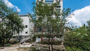 Un bâtiment traditionnel avec une façade blanche, de nombreuses fenêtres et un balcon.