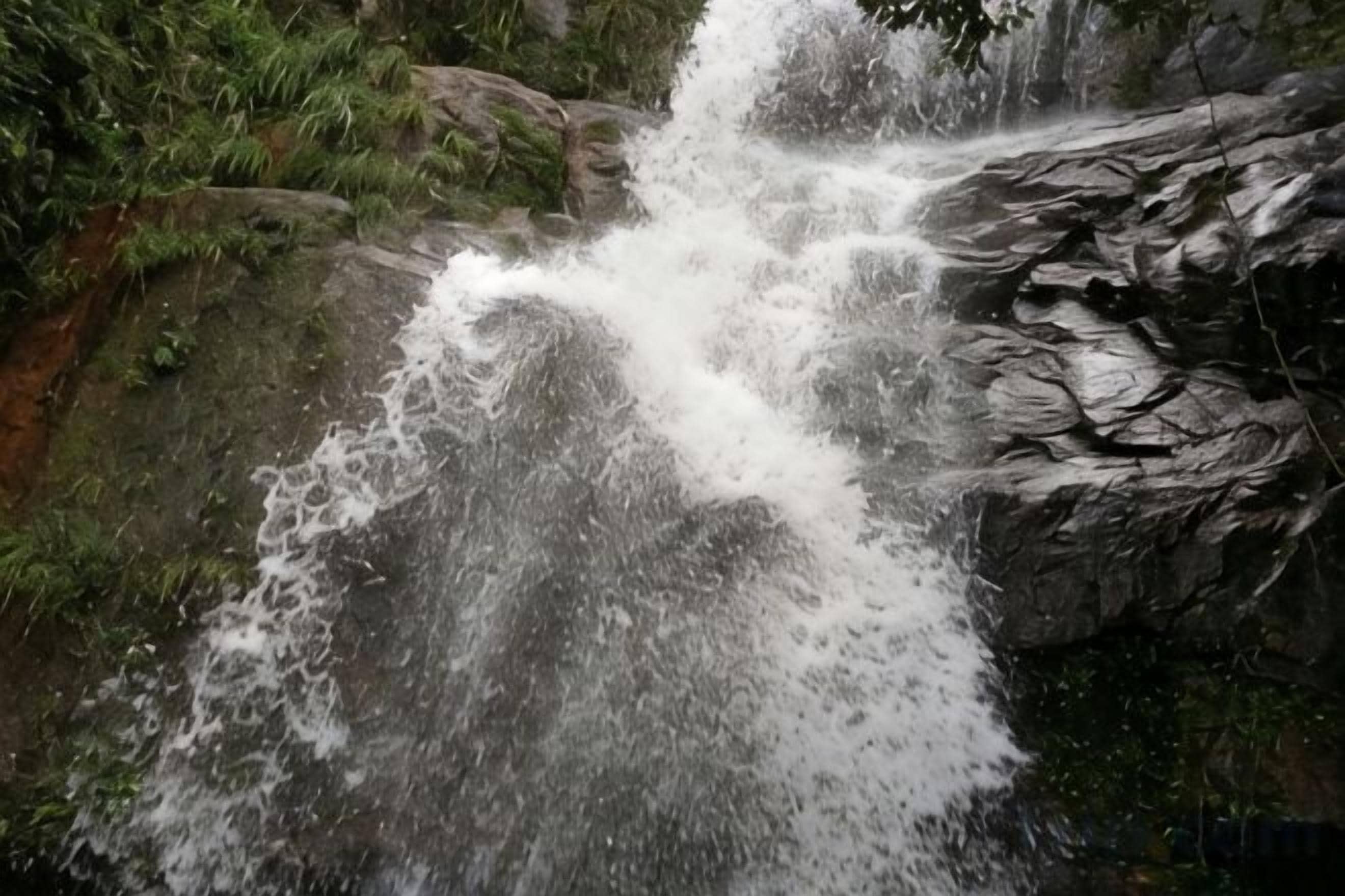 A waterfall cascading over rocks in a natural setting.