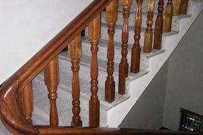 A wooden staircase with a handrail and a white wall. - He'an Renjia Farm Stay (Wuyuan)