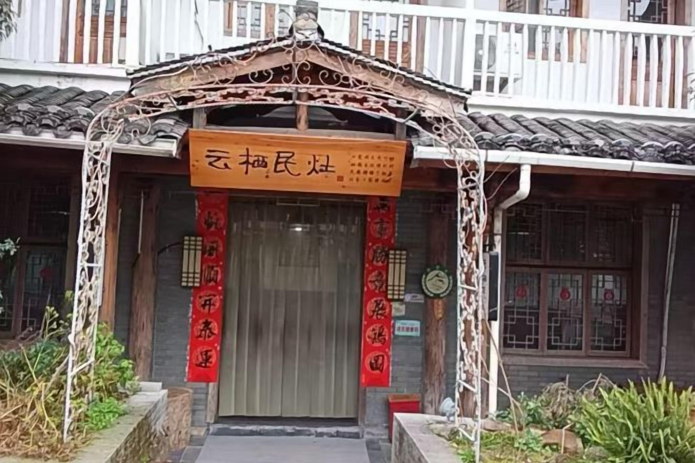 A traditional building with a tiled roof, a wooden facade, and a signboard above the entrance.