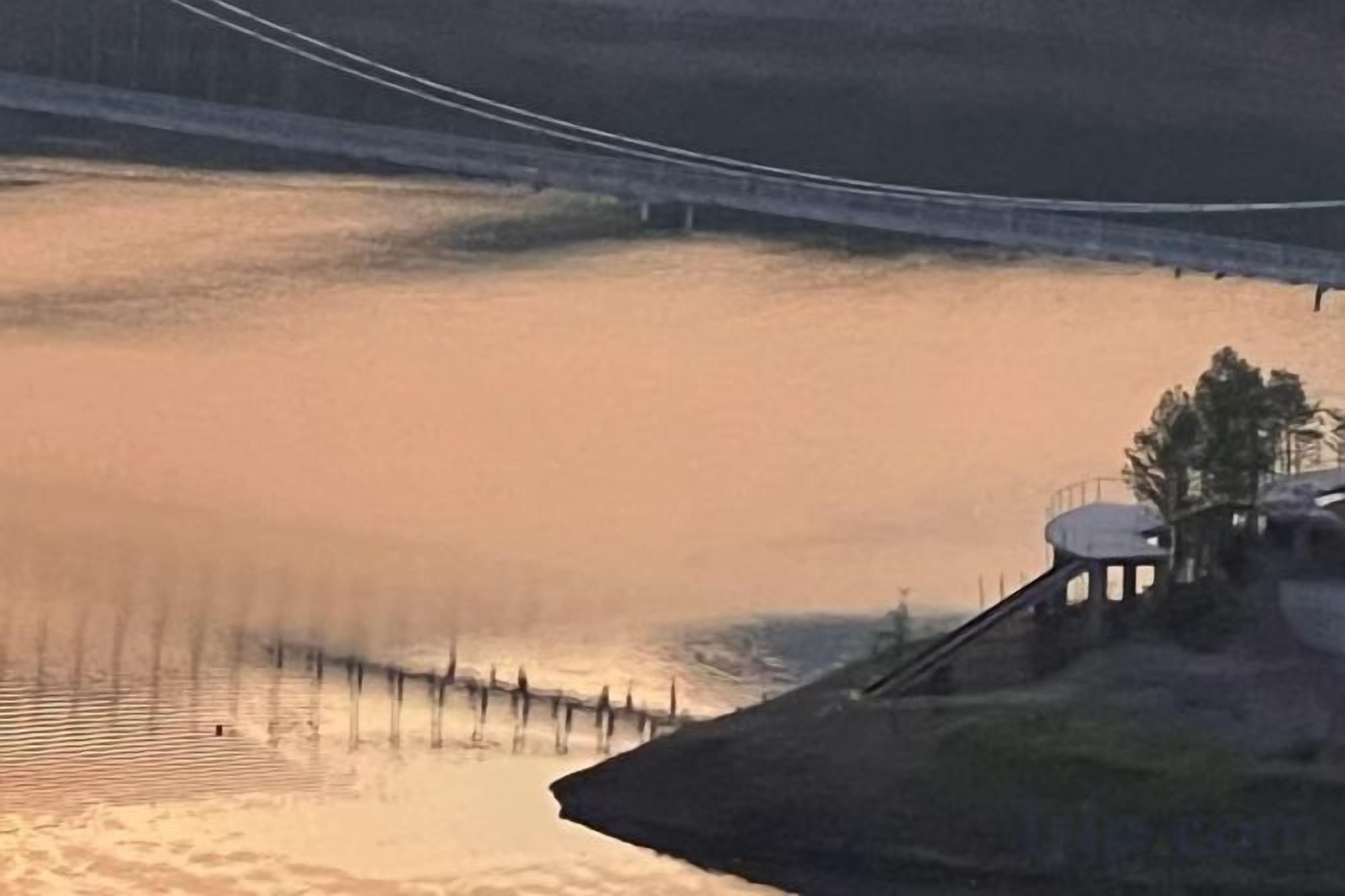 A calm body of water with a bridge in the background.