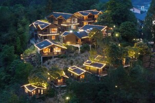 Um conjunto de cabanas de madeira com vários níveis e varandas, cercadas por uma floresta densa.