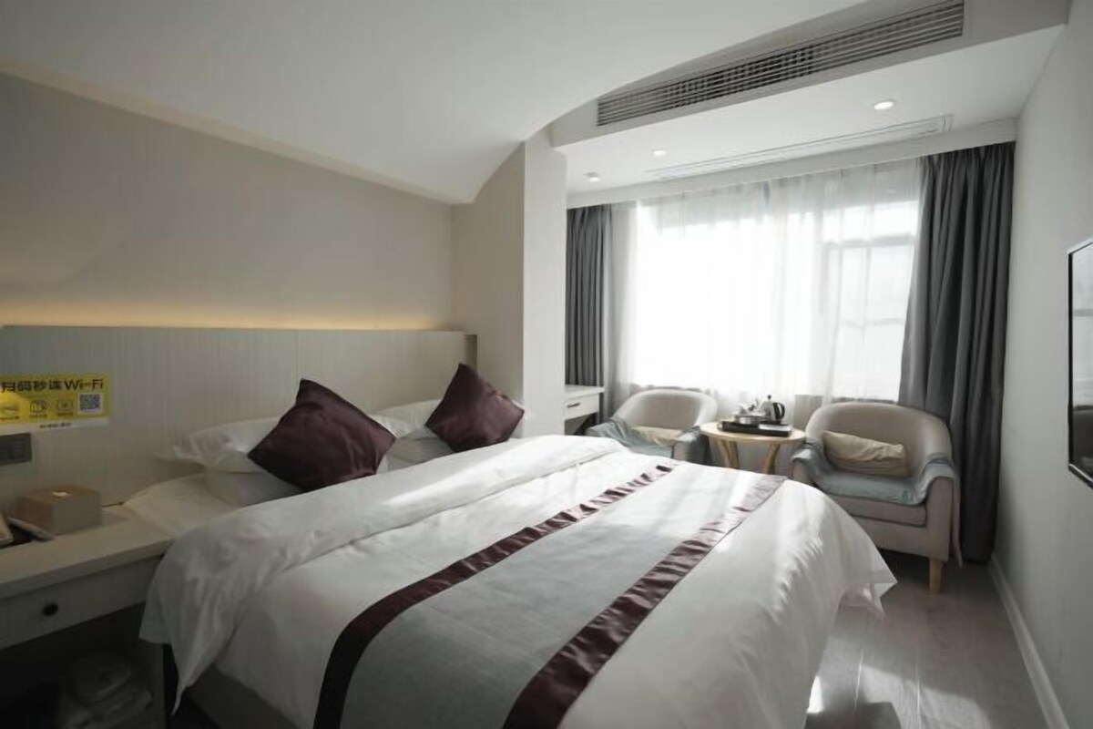 Una habitación de hotel con una cama grande, un escritorio, una silla y una mesita.