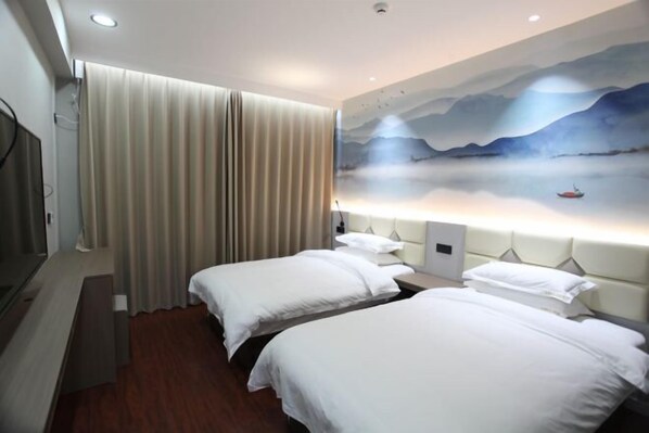 Une chambre d’hôtel avec deux lits, un tableau représentant un paysage accroché au mur et une vue sur la mer.