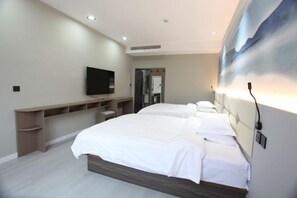 A modern hotel room with a large bed, a TV, a built-in shelf, and a wall-mounted air conditioning unit. - Longshangong Hotel (Taihu County)
