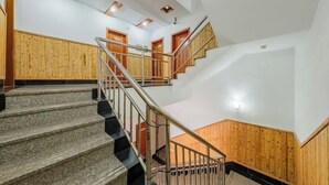 A multi-level interior with a central staircase, wooden paneling, and a modern design. - Wuzhen Zhonglitunta Chinese Inn (Tongxiang)