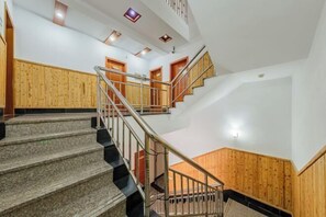 Stairs lead to multiple rooms with wooden paneling and recessed lighting.